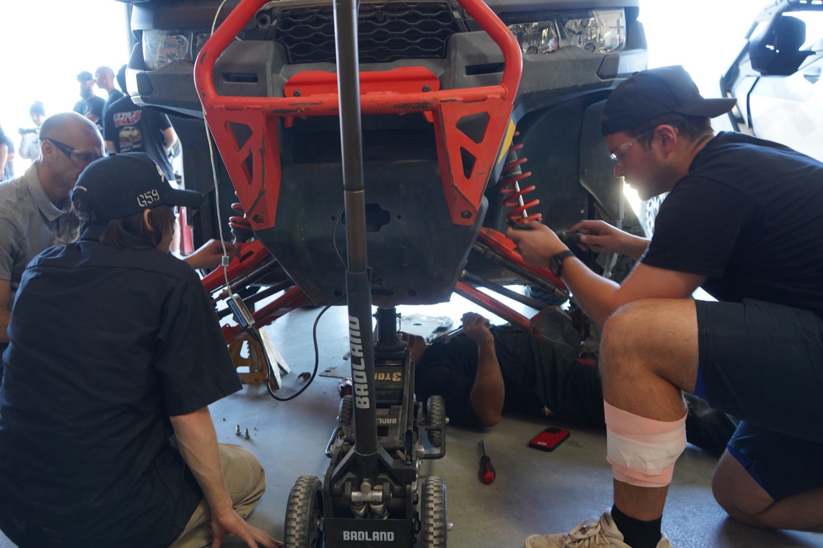 Under the front end of a UTV, working on the suspension